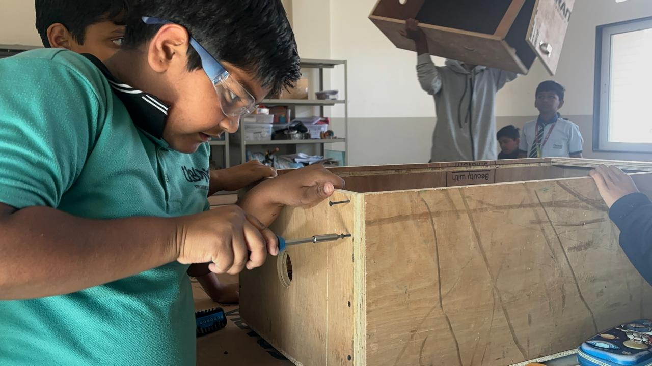 A student building a project by hand in a school workshop